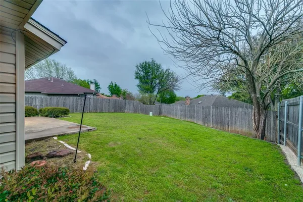 a backyard of a house with table and chairs