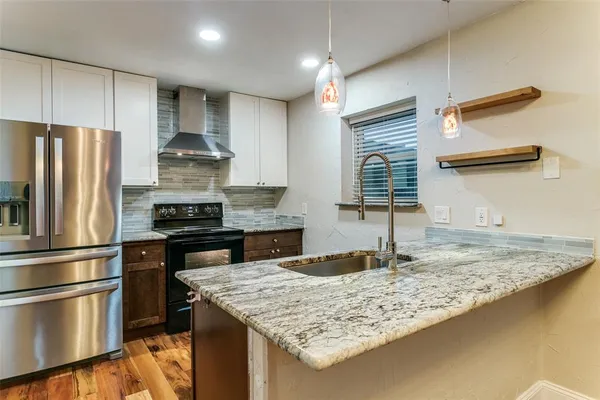 a kitchen with stainless steel appliances granite countertop a sink stove and refrigerator