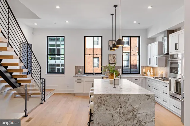 a view of a kitchen with granite countertop a sink and a refrigerator