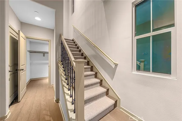 a view of staircase with lots of frames on wall and a window