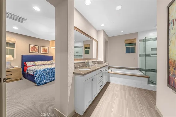 a spacious bathroom with a tub double vanity sink and mirror