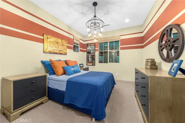 a bedroom with a bed and a chandelier