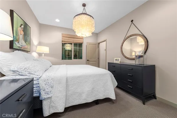 a bedroom with a bed and dresser with mirror