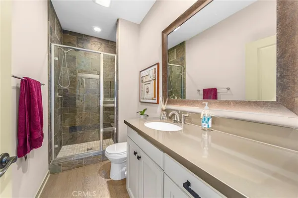 a bathroom with a shower sink vanity mirror and toilet