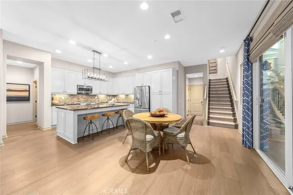 a kitchen with a table chairs a sink dishwasher and cabinets