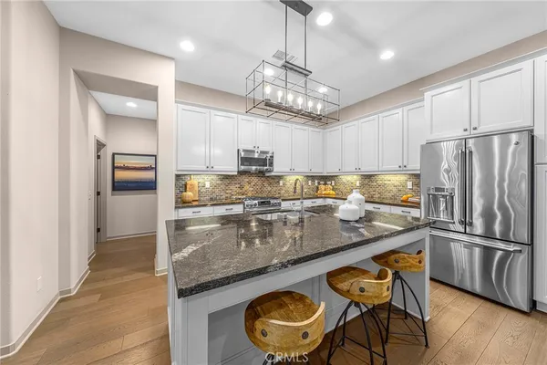 a kitchen with stainless steel appliances granite countertop a sink refrigerator and cabinets