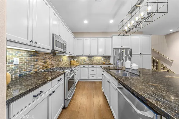 a large kitchen with stainless steel appliances granite countertop a lot of counter space