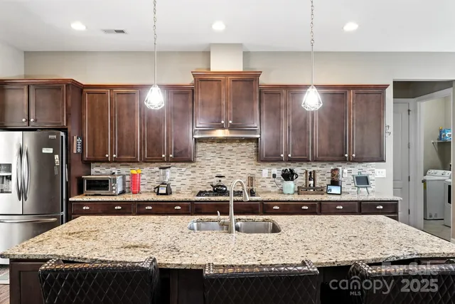 a kitchen with granite countertop a sink a counter top space and cabinets