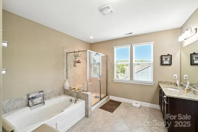 a spacious bathroom with a tub sink and mirror