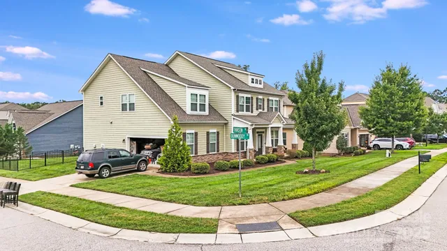 a view of a white house with a yard table and chairs