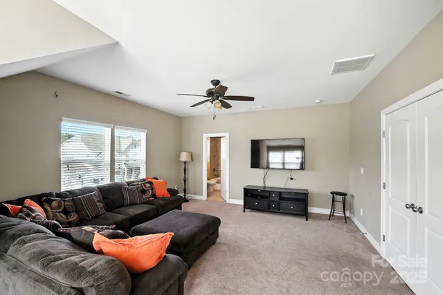a living room with furniture ceiling fan and a window