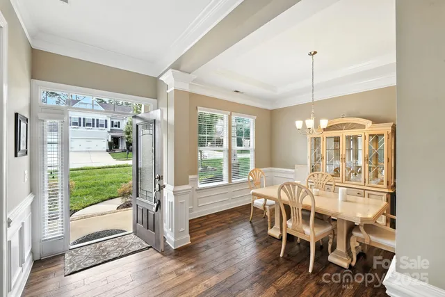 a dining room with wooden floor glass table and chairs