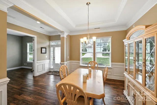a living room with furniture a large window and wooden floor