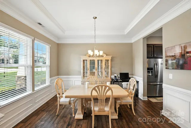 a dining room with furniture a chandelier and wooden floor
