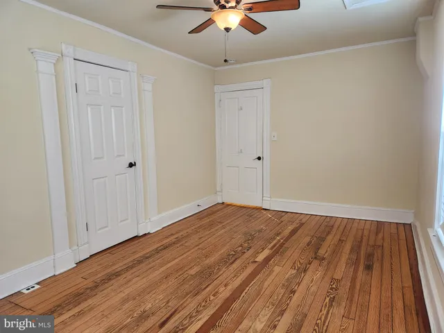 a view of room with hardwood floor and ceiling fan