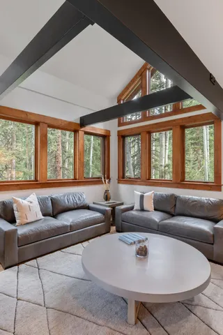 a living room with furniture and floor to ceiling windows