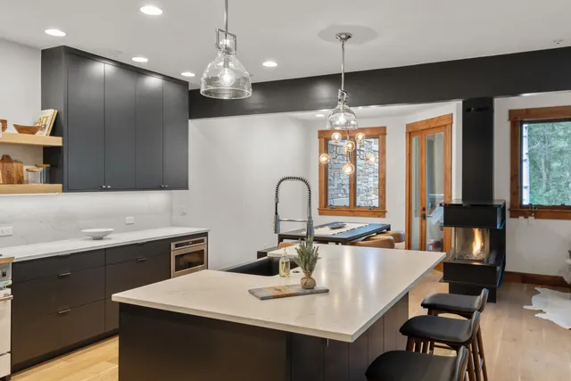 a kitchen with a sink a stove and chairs