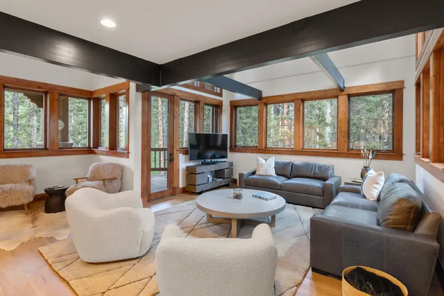 a living room with furniture and floor to ceiling windows