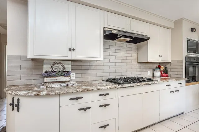 a kitchen with stainless steel appliances granite countertop a sink stove and cabinets