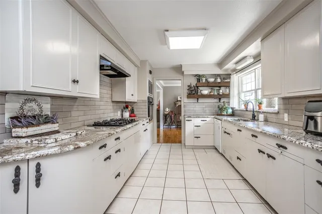 a kitchen with stainless steel appliances granite countertop a stove sink and cabinets