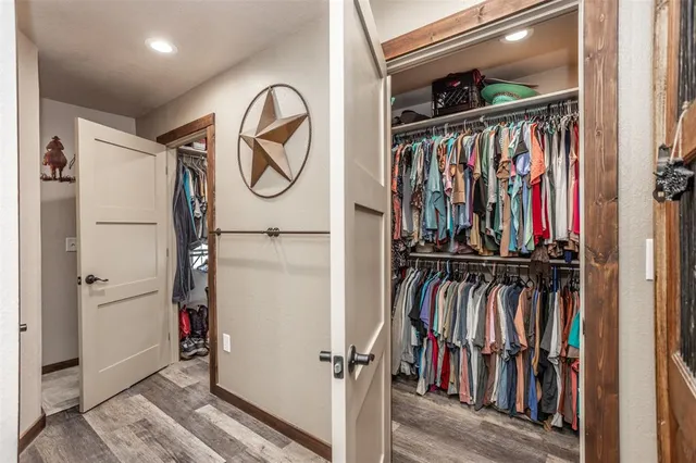 a view of walk in closet with clothes and shoes