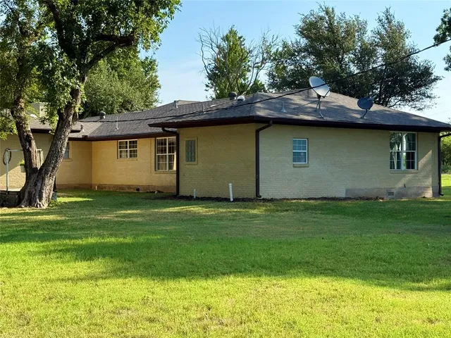 a backyard of a house with plants and wooden fence