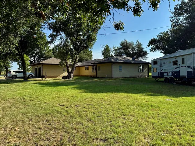 a front view of a house with a yard and trees