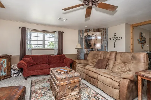a living room with furniture ceiling fan and a window
