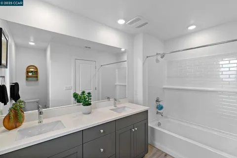 a bathroom with a granite countertop sink mirror and a bathtub