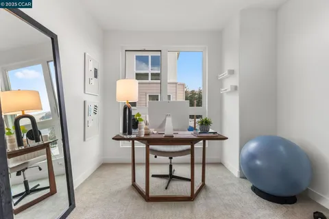 a view of a workspace room with wooden floor and furniture