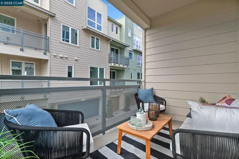 a view of a patio with couches chairs and wooden floor