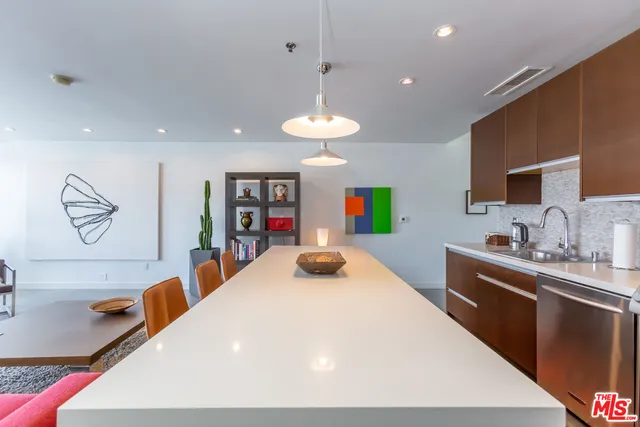 a kitchen with stainless steel appliances a sink dining table and chairs