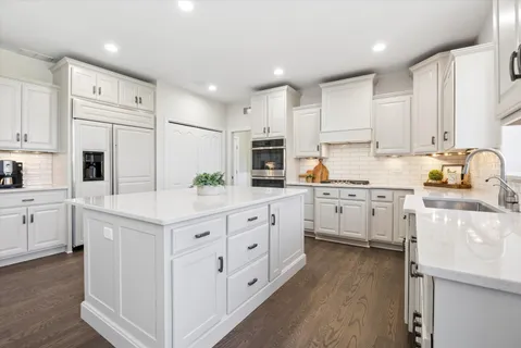 a kitchen with white cabinets and white appliances