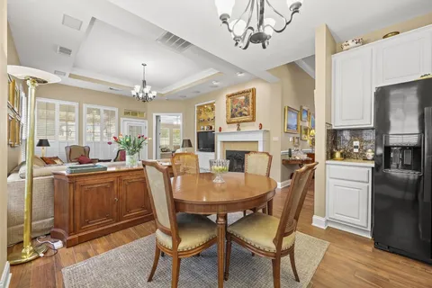 a view of a dining room with furniture a chandelier and wooden floor