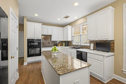 a kitchen with stainless steel appliances white cabinets and a refrigerator