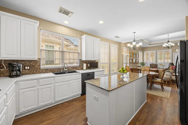 a spacious bedroom with a bed a couch and a chandelier