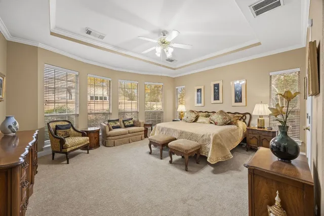 a spacious bedroom with a bed a window and a flat screen television