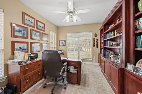 a view of a workspace with furniture and a bookshelf