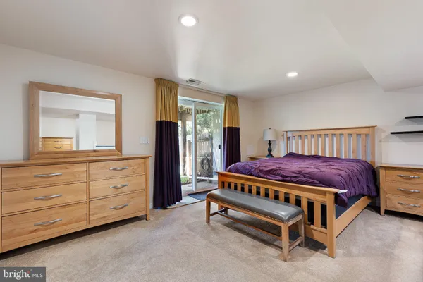 a spacious bedroom with a bed and a dresser