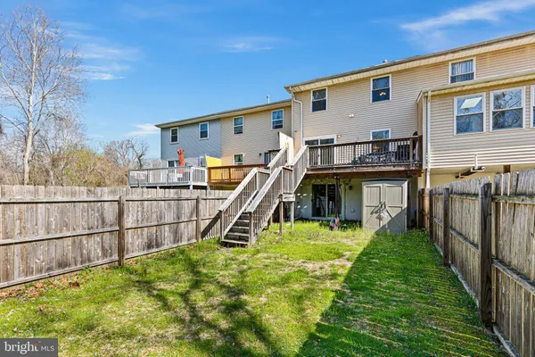 a view of a house with a small yard and a wooden deck