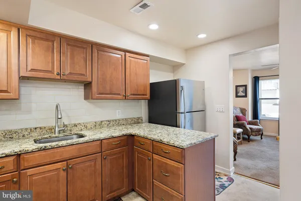 a kitchen with kitchen island granite countertop a sink stove and refrigerator