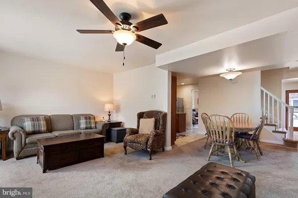 a living room with furniture a ceiling fan and a rug