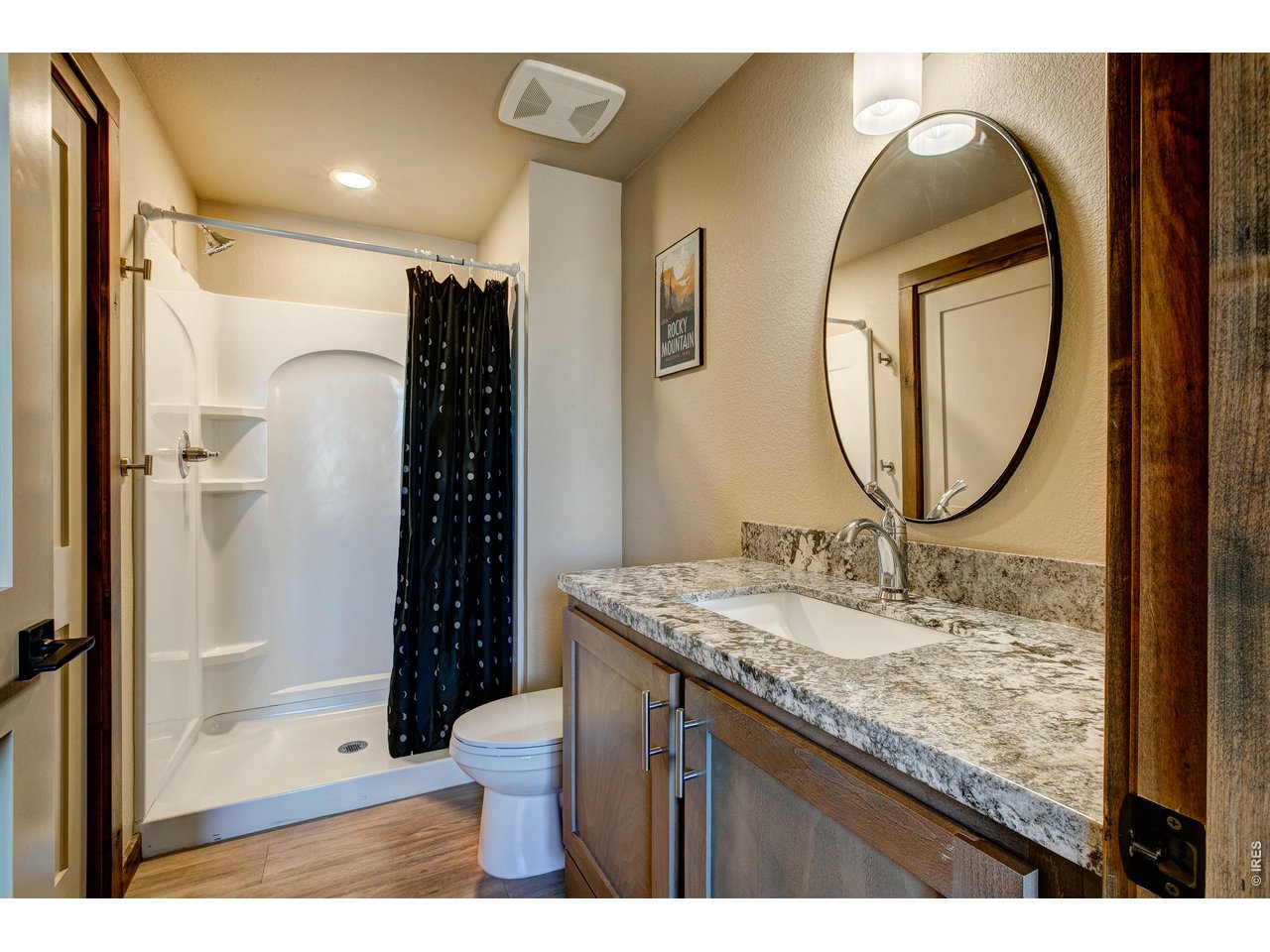 1802 Wildfire Road, Unit 204 Estes Park, CO 80517 - Photo 18 of 35 a bathroom with a granite countertop sink a mirror and a shower