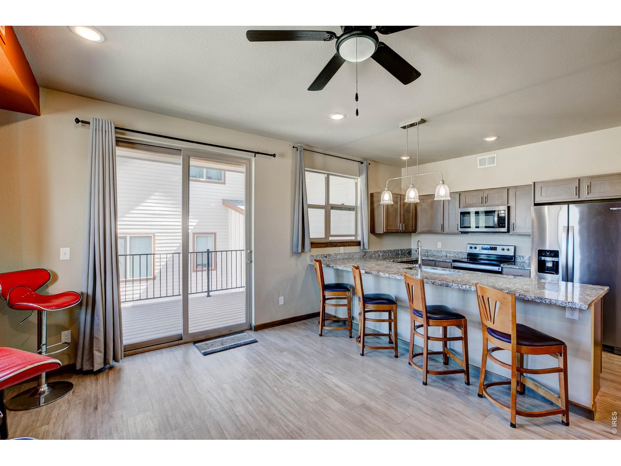 1802 Wildfire Road, Unit 204 Estes Park, CO 80517 - Photo 3 of 37 a open kitchen with stainless steel appliances granite countertop a dining table chairs refrigerator and sink