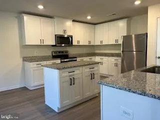 a kitchen with stainless steel appliances granite countertop a stove a sink and a refrigerator