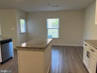 a kitchen with granite countertop cabinets stainless steel appliances a sink and a window