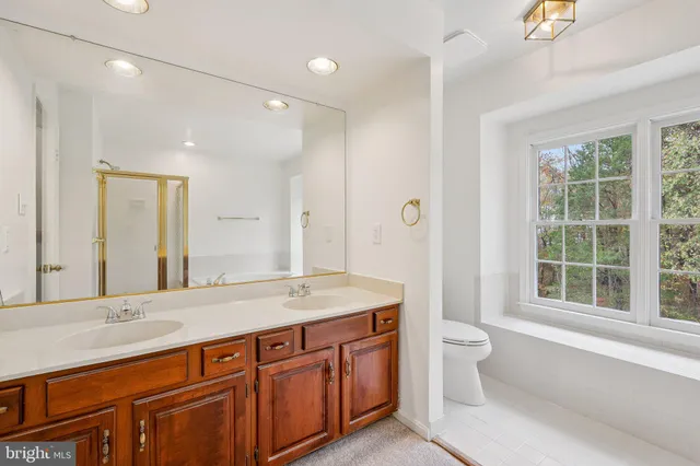 a bathroom with a granite countertop sink and a large mirror