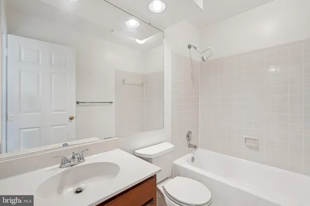 a bathroom with a tub sink toilet and a mirror