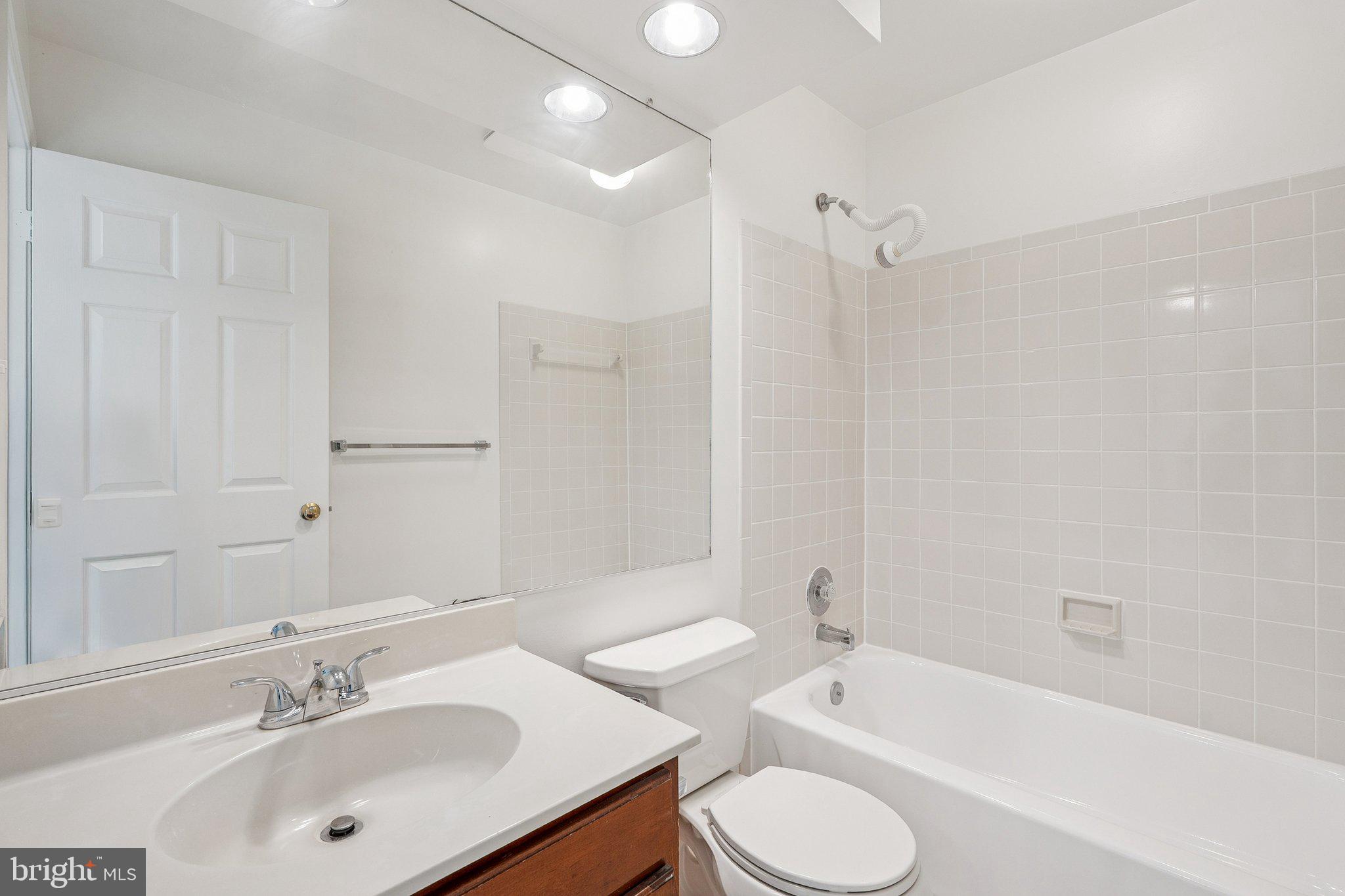 15056 Brown Post Lane Centreville, VA 20121 - Photo 31 of 45 a bathroom with a tub sink toilet and a mirror