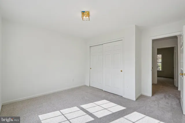an empty room with windows and closet